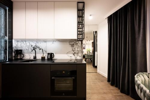 a kitchen with a sink and a stove at Native Apartments Kościuszki 39 in Kraków