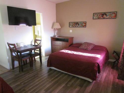 1 dormitorio con cama, mesa y escritorio en True North Motel, en Colorado Springs