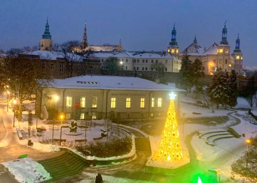 un arbre de Noël devant un bâtiment la nuit dans l'établissement Apartamenty Sienkiewicza - bezpłatny parking, centrum, park, fv, à Kielce