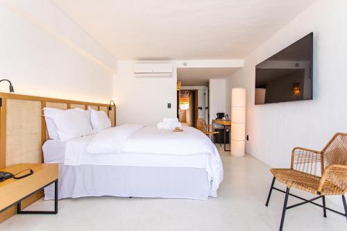 um quarto com uma grande cama branca e uma secretária em Apenunga Eco Hotel em Jericoacoara