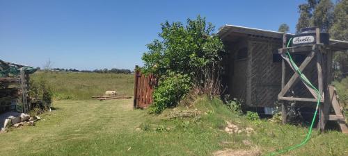 een hek en een hek in een veld met een schaap bij Chacrita Aguaribay in Villa Argentina