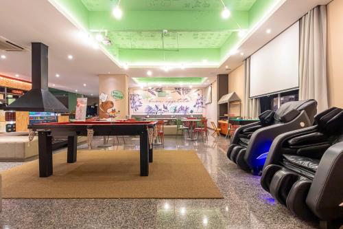 a room with a ping pong table and chairs at Hotel Nacional Inn Curitiba Santa Felicidade in Curitiba