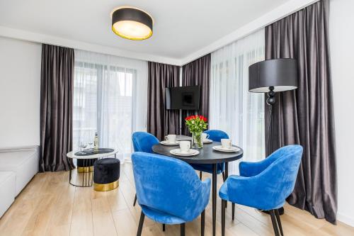 a dining room with blue chairs and a table at Grapa Ski - apartament Białka Tatrzańska in Białka Tatrzanska