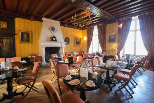 a dining room with tables and chairs and a fireplace at Château De Pray in Amboise