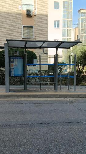 a bus stop with a bus on a street at El Colmenar Habitaciones in Madrid