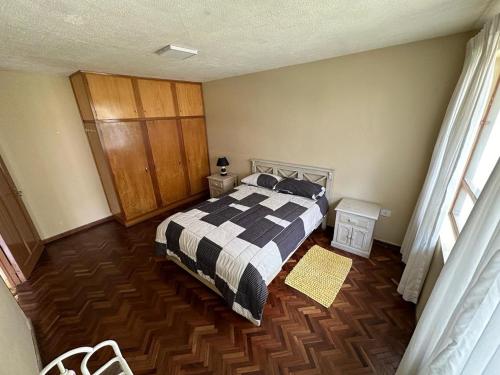 um quarto com uma cama e piso em madeira em Acogedor Dpto. Con Jardin P.Baja em Cochabamba