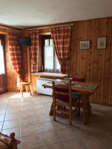 a dining room with a table and a television at Appartamento Monte Rosa in Champoluc