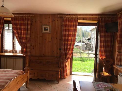 a bedroom with a bed and a sliding glass door at Appartamento Monte Rosa in Champoluc