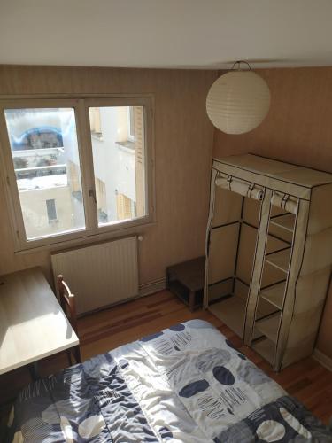 een kamer met een bed, een bureau en een raam bij Chambres dans appartement partagé in Grenoble