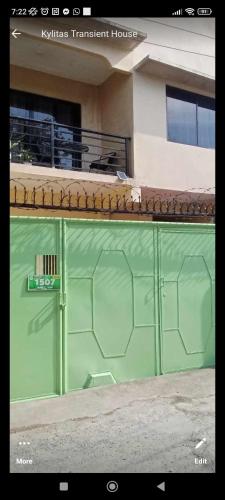 a green tennis fence in front of a building at Kylitas transient house studio apartment 1st floor in Tagbilaran City