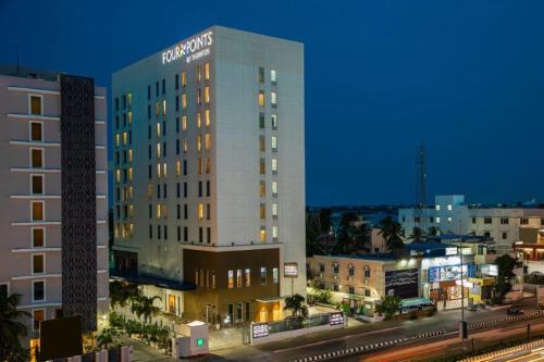 a large hotel building in a city at night at Four Points by Sheraton Chennai OMR in Chennai