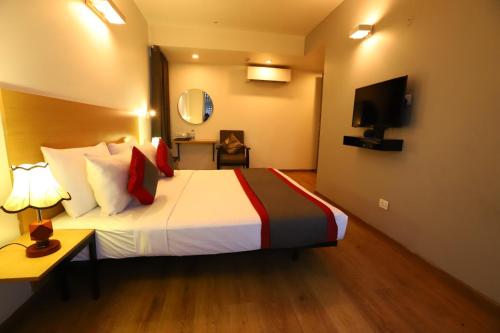 BK Studio And Rooms Near Huda City Centre في جورجاون: غرفه فندقيه سرير وتلفزيون