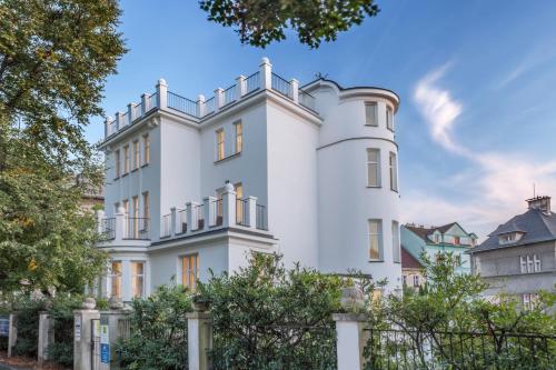 una casa blanca con una valla delante en Apartments Villa Whitehouse, en Ostrava