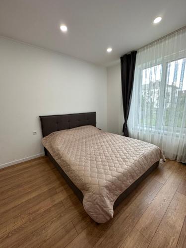 uma cama num quarto com uma grande janela em Modern apartament em Mukachevo