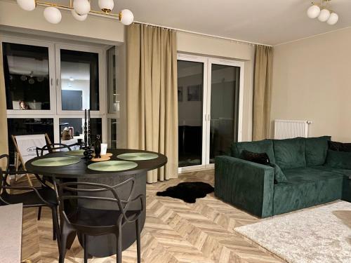 uma sala de estar com um sofá verde e uma mesa em Apartament Twój ZDRÓJ & SPA Dr Duda em Busko-Zdrój