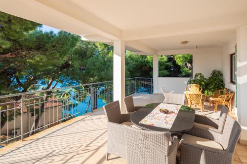 a patio with a table and chairs on a balcony at Urban Edge - Beach Apartments in Omiš