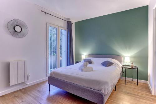 a bedroom with a bed with a teddy bear on it at Le Petit Nid - Apt Lumineux en Hypercentre in Montigny-le-Bretonneux