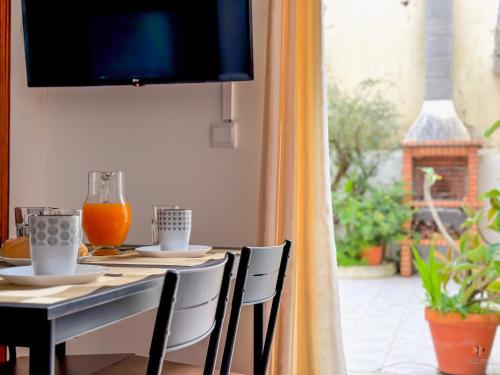 een eettafel met stoelen en jus d'orange bij Pátio Privado com Churrasqueira by Férias em Figueira in Figueira da Foz