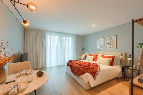 a bedroom with a large bed and a table at Nôma Living Icon Apartments in Porto