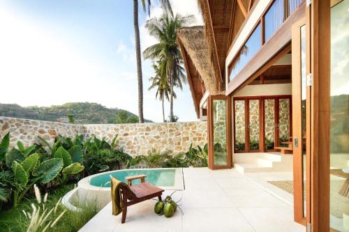 een extern uitzicht op een huis met een zwembad bij Tias Villas in Kuta Lombok