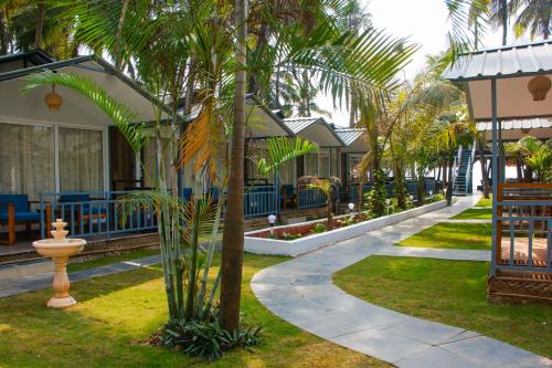 een resort met palmbomen en een loopbrug bij COCO CABANA in Palolem