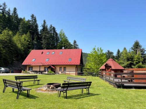 un groupe de bancs assis dans l'herbe devant une maison dans l'établissement Willa Arga, à Piwniczna-Zdrój