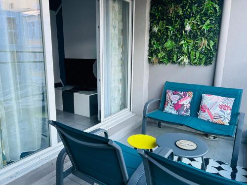 d'un balcon avec des chaises, une table et une télévision. dans l'établissement Le 13OR - Appartement plein centre parking et terrasse, à Marseille