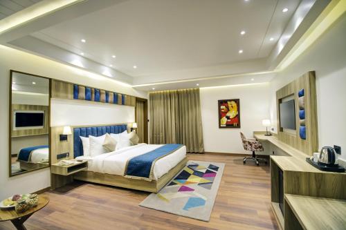 a hotel room with a bed and a desk at Cygnett Style Ganga in Jaipur