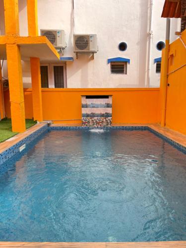 una piscina en un edificio con paredes de color naranja y agua en Serenity Bay Home Stay, en Pondicherry