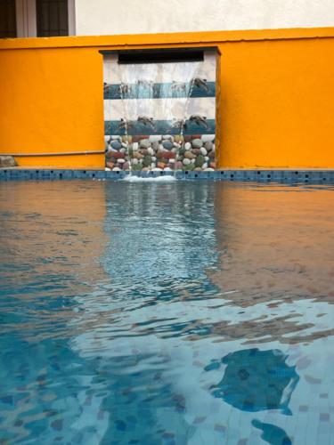 una piscina con agua frente a un edificio en Serenity Bay Home Stay, en Pondicherry