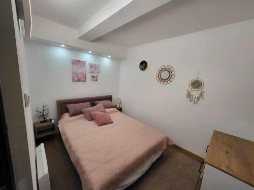 ein Schlafzimmer mit einem Bett mit rosa Kissen darauf in der Unterkunft Apartman Nina, Kopaonik, Brzeće, Kod Gondole in Brzeće