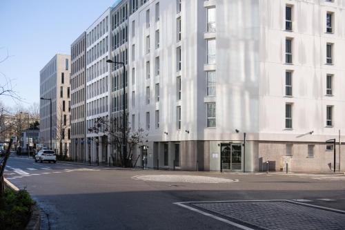 eine leere Straße vor einem großen weißen Gebäude in der Unterkunft Hôtel de la Cité in Nantes