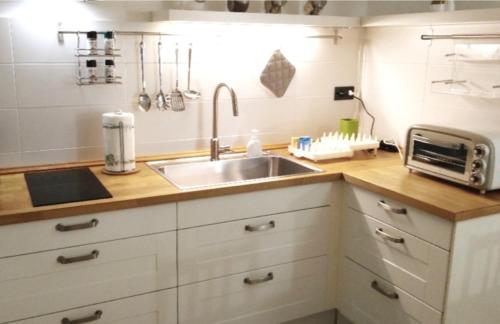 a kitchen counter with a sink and a microwave at Casa Pallamaio Historic Center Vicenza in Vicenza