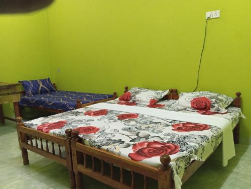 een slaapkamer met een bed met rode rozen erop bij NMA Holiday Inn in Jaffna