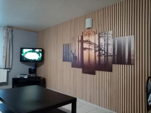 een woonkamer met een tafel en een televisie bij Gîte de la barrière in Libin