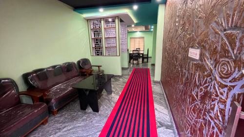 a living room with a couch and a red carpet at Welldone Wayanad Holidays in Sultan Bathery