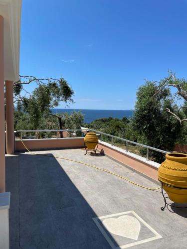 einen Balkon mit zwei gelben Behältern auf einem Dach in der Unterkunft Alex Bar APARTMENTS SARAKINIKO in Parga