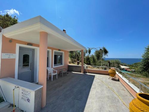 ein Haus mit einer großen Terrasse mit Meerblick in der Unterkunft Alex Bar APARTMENTS SARAKINIKO in Parga