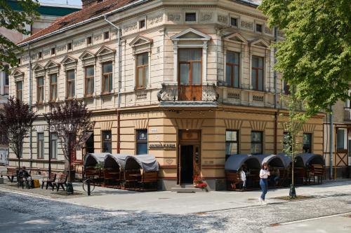 Uma mulher está em frente a um edifício. em Lama Hostel em Ivano-Frankivsk