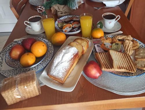 - une table avec petit-déjeuner composé de pain et de fruits dans l'établissement Agathi's house, à Mitikas