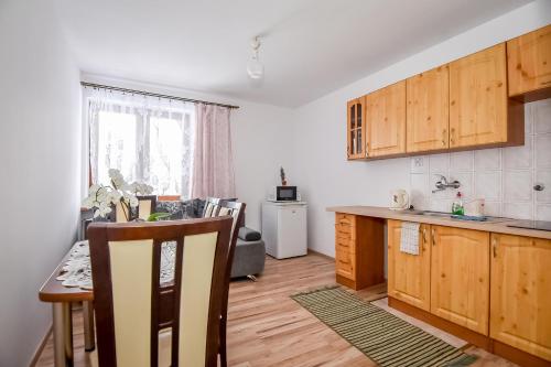 une cuisine avec des placards en bois et une table avec une table dans l'établissement Apartamenty u Gabi, à Poronin