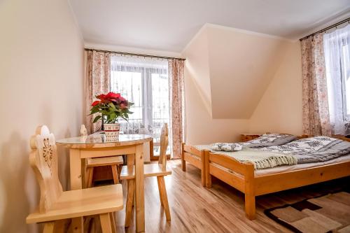 - une chambre avec un lit, une table et un bureau dans l'établissement Apartamenty u Gabi, à Poronin