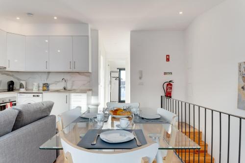 a kitchen and a dining room with a glass table at Lapa Duplex Apartment in Lisbon