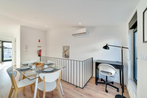 a dining room with a glass table and chairs at Lapa Duplex Apartment in Lisbon