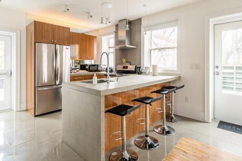 a kitchen with a large island with bar stools at Spacious 2 Bedroom Loft in Sought After Leslieville in Toronto