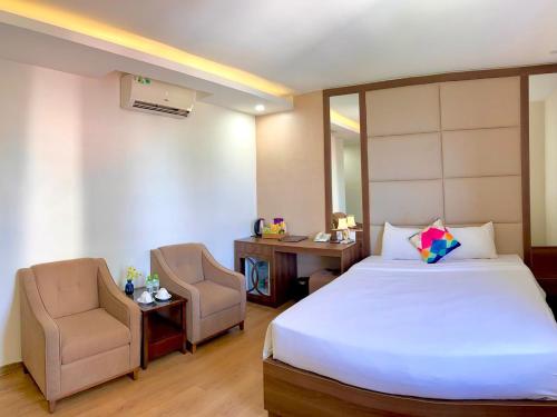 1 dormitorio con cama, escritorio y silla en Pariat River Front Hotel, en Da Nang