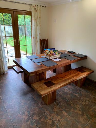 una mesa de madera y un banco en una habitación en Tanglewood Lodge, en Lossiemouth