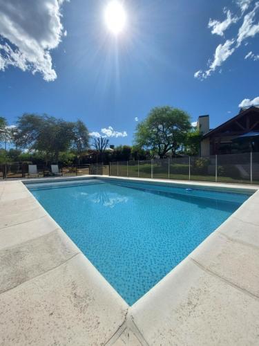 uma piscina com um céu azul ao fundo em Le Bel-Edén em Villa General Belgrano