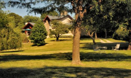 uma casa no meio de um quintal com uma árvore em Le Bel-Edén em Villa General Belgrano