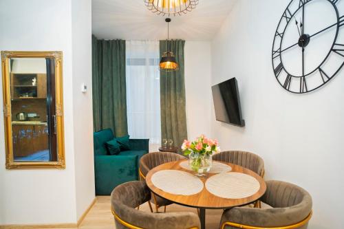 une salle à manger avec une table, des chaises et une horloge dans l'établissement Central Station Apartment No1, à Kaunas